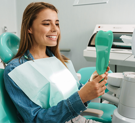 Dental patient looking at her smile in a mirror