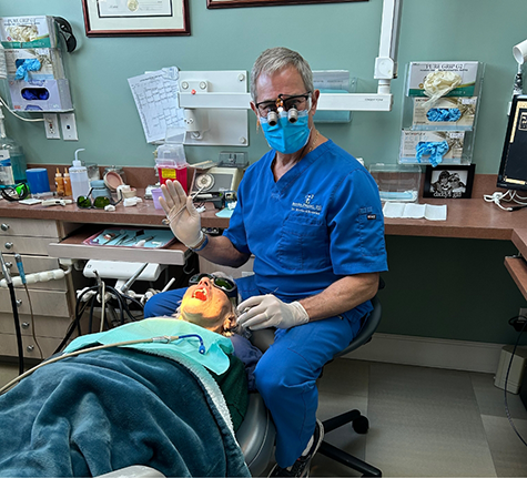 Doctor Howard waving next to a patient in the treatment chair
