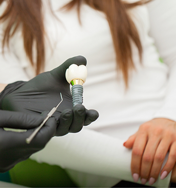 Dentist showing a dental implant to a patient
