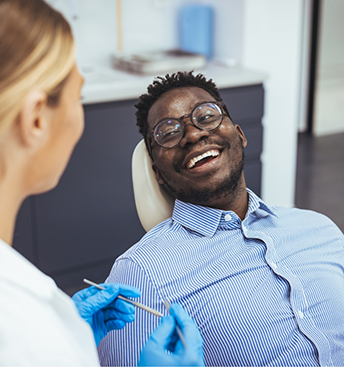 Man in the dental chair grinning at his dentist