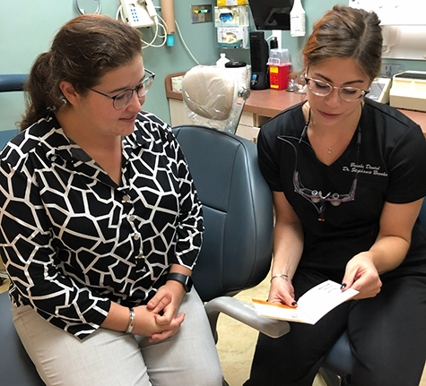 Person typing on a calculator on a desk