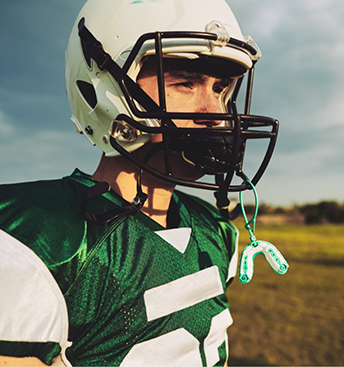 Football player with a mouthguard attached to their helmet
