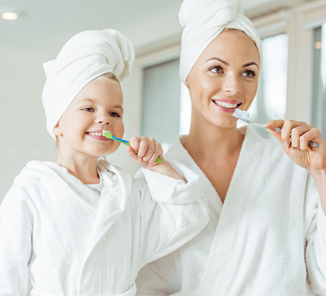 Mother and daughter brushing their teeth