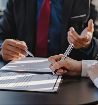 Two people discussing paperwork at a table