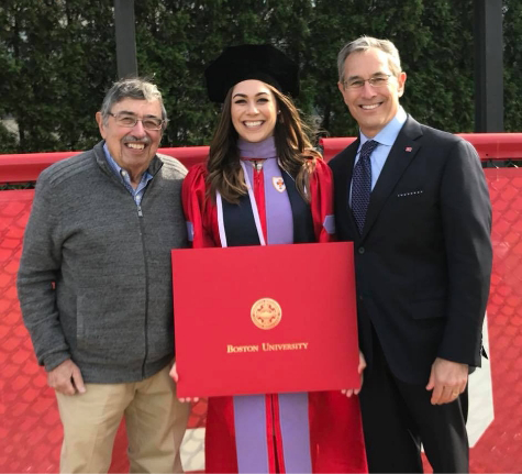 Doctor Stephanie at graduation holding her diploma with her father and grandfather