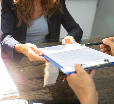 Dental team member handing a clipboard to a patient