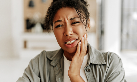 Woman holding her cheek in pain