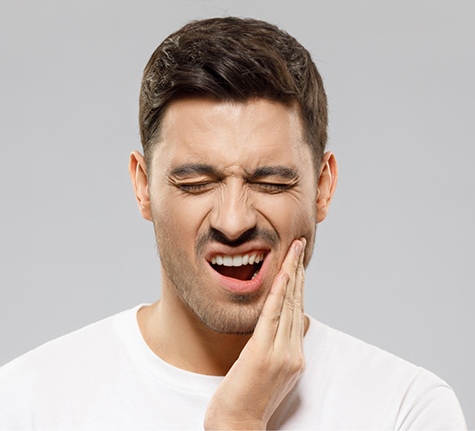 Man holding the side of his jaw in pain