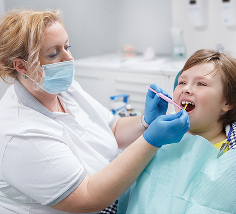 Child in the dental chair getting fluoride placed on their teeth