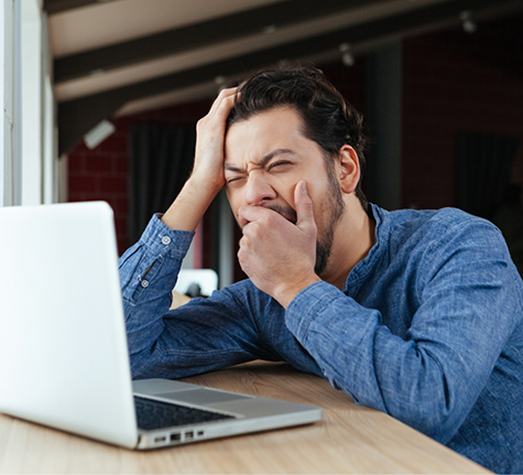 Man yawning at his work desk