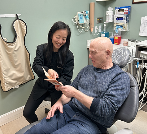 Dentist showing a pamphlet to a senior man in the treatment chair