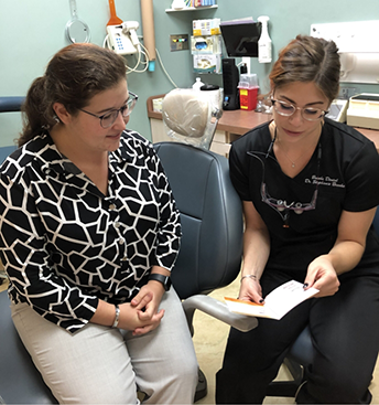 Dental team member showing a pamphlet to a patient