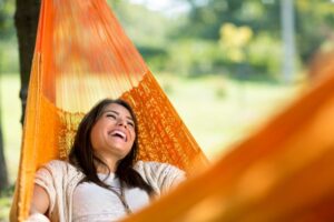 woman smiling and relaxing in a hammock
